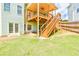 A lush green backyard with a wooden deck, stairs, green grass and a well maintained lawn at 2727 Lost Mill Trce, Buford, GA 30519