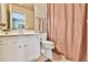Well-lit bathroom with a single sink vanity, neutral walls, and a shower with a pink curtain at 2727 Lost Mill Trce, Buford, GA 30519