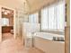 Bright bathroom with a tub, glass enclosed shower and neutral tile at 2727 Lost Mill Trce, Buford, GA 30519