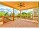 Spacious covered deck with ceiling fan, wood flooring and railings with view of backyard and neighborhood at 2727 Lost Mill Trce, Buford, GA 30519