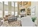 Bright living room with soaring ceilings, stone fireplace, and a wall of windows providing ample natural light at 2727 Lost Mill Trce, Buford, GA 30519