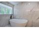 Soaking tub with a window, marble floors and walls at 3880 Northpoint Dr, Marietta, GA 30062