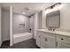 Modern bathroom features a tiled shower-tub and sleek vanity with black hardware at 3880 Northpoint Dr, Marietta, GA 30062