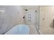 Modern bathroom with a frameless glass shower, soaking tub, and elegant marble tiling at 3880 Northpoint Dr, Marietta, GA 30062