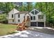 Contemporary home with striking design and black garage doors nestled among mature trees and lush landscaping at 3880 Northpoint Dr, Marietta, GA 30062