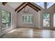 Open living room with cathedral ceilings, wood beams, many windows, hardwood floors, and modern chandelier at 3880 Northpoint Dr, Marietta, GA 30062