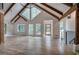 Spacious living room with vaulted ceilings, wood beams, many windows, wood floors, and modern chandelier at 3880 Northpoint Dr, Marietta, GA 30062
