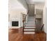 Hardwood staircase featuring iron spindles and open floor plan to the living room with fireplace at 4656 Ivygate Se Cir, Atlanta, GA 30339