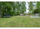 Expansive backyard featuring a trampoline, storage shed, and raised garden beds at 5531 Hurstcliffe Nw Dr, Kennesaw, GA 30152
