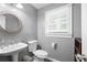 Charming powder room with a round mirror, pedestal sink and stylish gray walls at 5531 Hurstcliffe Nw Dr, Kennesaw, GA 30152