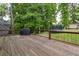Spacious wooden deck with grill, overlooking a large backyard and lush trees at 5531 Hurstcliffe Nw Dr, Kennesaw, GA 30152
