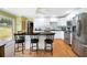 Bright kitchen with white cabinets, granite counters, island seating, stainless appliances, and backyard view at 5531 Hurstcliffe Nw Dr, Kennesaw, GA 30152