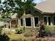 Stone and brick home exterior featuring a pergola, multiple windows, and an outdoor dining area at 3397 Holly Glen Dr, Dacula, GA 30019