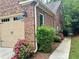 Brick home featuring an attached garage, complemented by landscaped bushes, trees and a walkway at 3397 Holly Glen Dr, Dacula, GA 30019