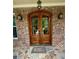 Elegant double front door with glass panels, set within a brick archway and stone tile porch at 3397 Holly Glen Dr, Dacula, GA 30019