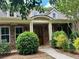 Inviting brick home featuring a covered front porch with a stained wood front door and manicured landscaping at 3397 Holly Glen Dr, Dacula, GA 30019