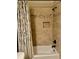 Tiled shower-tub combo features dark hardware and decorative details at 3397 Holly Glen Dr, Dacula, GA 30019