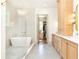 Luxurious bathroom featuring a standalone tub, glass-enclosed shower, and elegant vanity with marble countertops and wooden drawers at 4785 Brinkley Ln, Atlanta, GA 30342