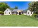 Stately home with a manicured lawn, stone and siding facade, and classic architectural details at 4785 Brinkley Ln, Atlanta, GA 30342