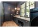 Sophisticated laundry room with dark cabinetry, a stylish sink area, and modern appliances, enhancing functionality and design at 4785 Brinkley Ln, Atlanta, GA 30342