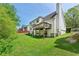 Exterior view of the home's backyard with a lush green lawn, wooden deck, and patio at 930 Palmer Rd, Lithonia, GA 30058