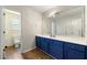 Bathroom featuring a vanity with blue cabinets, a large mirror, and linoleum flooring at 930 Palmer Rd, Lithonia, GA 30058