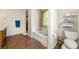 Relaxing bathroom featuring a soaking tub, white toilet, and plenty of natural light at 930 Palmer Rd, Lithonia, GA 30058