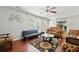 Comfortable living room featuring a ceiling fan, hardwood floors, and cozy seating arrangements at 930 Palmer Rd, Lithonia, GA 30058