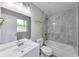 Bright bathroom featuring modern vanity, tub with gray marble-style tile, and updated fixtures at 1660 Mallard Cir, Conley, GA 30288
