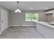 Kitchen and dining area with wood-look floors and stainless faucet, featuring a hanging light fixture at 1660 Mallard Cir, Conley, GA 30288