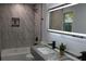Modern bathroom featuring gray marble tile, a sleek lighted mirror and black fixtures at 257 E Simon Nw Ter, Atlanta, GA 30318