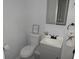 Half bath featuring a white toilet and sink, gray vanity, and decorative wall accents at 257 E Simon Nw Ter, Atlanta, GA 30318