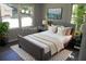 This staged bedroom shows a bed with a padded headboard and two windows with natural lighting at 257 E Simon Nw Ter, Atlanta, GA 30318