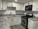 Updated kitchen featuring modern appliances, granite countertops, and white cabinetry at 257 E Simon Nw Ter, Atlanta, GA 30318