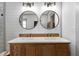 Elegant double vanity with round mirrors, wood cabinetry, and stylish fixtures in updated bathroom at 275 Crowe Springs Nw Rd, Cartersville, GA 30121