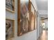 Hallway with curated portraits and hardwood floors leading to sun-drenched rooms at 275 Crowe Springs Nw Rd, Cartersville, GA 30121