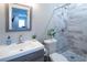 Neutral toned bathroom with walk-in shower, gray and white stone tile, and chrome fixtures at 4280 Castlewood Rd, Cumming, GA 30040