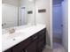 Bathroom with a white vanity, a mirror, and a door leading to a tiled shower/tub at 4280 Castlewood Rd, Cumming, GA 30040