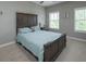 Bedroom featuring a rustic wooden bed frame and dual windows, filling the space with natural light at 4280 Castlewood Rd, Cumming, GA 30040