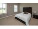 Bright bedroom with two windows and a cozy bed with a wooden headboard and a throw pillow at 4280 Castlewood Rd, Cumming, GA 30040