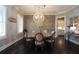 Bright dining room featuring wood floors, modern chandelier, neutral colors, table with seating for six at 4280 Castlewood Rd, Cumming, GA 30040