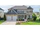 Charming two-story home showcasing a stone and siding facade with a well-manicured lawn and a two car garage at 4280 Castlewood Rd, Cumming, GA 30040