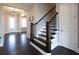 Inviting foyer with hardwood floors, staircase with dark wood banister, and elegant lighting at 4280 Castlewood Rd, Cumming, GA 30040