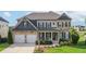 Stately two-story home with stone and siding exterior, manicured landscaping, and a two-car garage at 4280 Castlewood Rd, Cumming, GA 30040