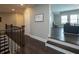 Hallway with wood floors and railings leading to an open room with large windows at 4280 Castlewood Rd, Cumming, GA 30040