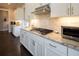 Well-lit kitchen with stainless steel appliances, light countertops, and white cabinetry and shelving at 4280 Castlewood Rd, Cumming, GA 30040