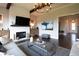 Open-concept living room with a white brick fireplace, coffered ceiling, and hardwood flooring at 4280 Castlewood Rd, Cumming, GA 30040