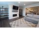 Comfortable living area with a fireplace, television, dark shelving, and gray fabric sofa set at 4280 Castlewood Rd, Cumming, GA 30040