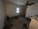 View of bedroom with ceiling fan, exposed lighting, window, and personal belongings at 6475 Church St, Atlanta, GA 30291