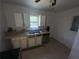 Modest kitchen features white cabinets and stainless steel dishwasher under a window at 6475 Church St, Atlanta, GA 30291
